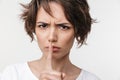 Beautiful young pretty displeased sad woman posing isolated over white wall background showing silence gesture