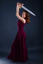 Beautiful young princess in long dress defending herself with a sword Royalty Free Stock Photo
