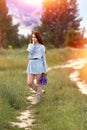 A beautiful young red-haired girl with blue eyes holds a pensive bouquet of wild flowers in her hands. Summer. Energy of nature. Royalty Free Stock Photo