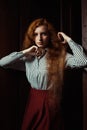 Beautiful young red haired model wearing white striped shirt and Royalty Free Stock Photo