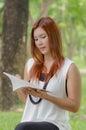 Beautiful young redhead Asian woman reading a book Royalty Free Stock Photo