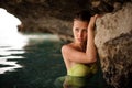 Beautiful young redhead girl with grey eyes in the water cave Royalty Free Stock Photo