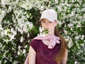 Beautiful young redhead woman in blossoming garden. Close up portrait.