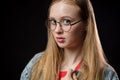Beautiful young redhead woman in glasses on a black background