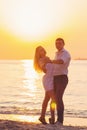 Beautiful young romantic couple dancing on seaside in rays of ri Royalty Free Stock Photo