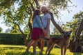 Beautiful young romantic curly haired couple hugging in the park while walking with their dog Royalty Free Stock Photo