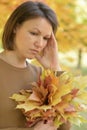 Portrait of beautiful young sad woman in autumnal park Royalty Free Stock Photo