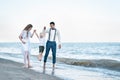 Beautiful young seven walk with a child on the seaside. Happy family on sea beach at resort Royalty Free Stock Photo