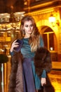 Beautiful young blonde wearing evening makeup in elegant fitting dress fashionable stylish expensive fur coat walk night stre