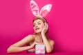 Beautiful young sexy bunny woman with prasent gift isolated on pink.