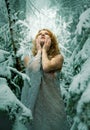 Beautiful young sexy christmas redhead snow girl with a big snowcrystal, in winter nature in a long light delicate dress in a cold