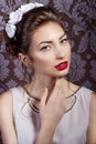 Beautiful young elegant woman with red lips, beautiful stylish hairstyle with white flowers in her hair, the way Royalty Free Stock Photo