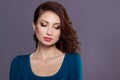 Beautiful young girl with curls with bright festive makeup, plump lips. the image to the new year, on Christmas evening