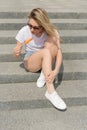 Beautiful young girl in sunglasses eating ice cream on the ladder and licking plump lips a bright sunny hot day Royalty Free Stock Photo