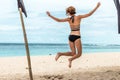 Beautiful young woman jumping for joy on the beach of tropical Bali island, Indonesia. Sunny summer day scene. Royalty Free Stock Photo