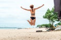 Beautiful young woman jumping for joy on the beach of tropical Bali island, Indonesia. Sunny summer day scene. Royalty Free Stock Photo