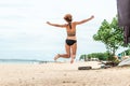 Beautiful young woman jumping for joy on the beach of tropical Bali island, Indonesia. Sunny summer day scene. Royalty Free Stock Photo
