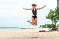 Beautiful young woman jumping for joy on the beach of tropical Bali island, Indonesia. Sunny summer day scene. Royalty Free Stock Photo