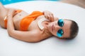 Beautiful young woman laying in bikini during sunbath next to swimming pool Royalty Free Stock Photo