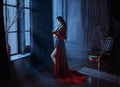 Beautiful young sexy woman vampire in medieval dark castle Red long gothic dress