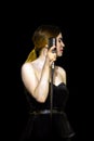 Beautiful young singer in black dress with a vintage microphone Royalty Free Stock Photo