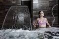 Woman relaxing in bubbling pool with water jet