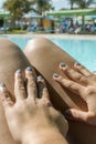 Beautiful young slim woman legs sunbathe near swimming pool. Girl sunbathing by the pool. vertical photo
