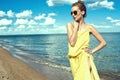 Beautiful young slim woman standing at the seaside and looking aside
