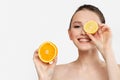 Beautiful young smile woman holding fresh lemon and orange slices. Skin care, spa, natural beauty and cosmetology concept Royalty Free Stock Photo