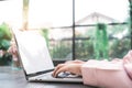 Beautiful young smiling asian muslim woman working on laptop sitting in living room at home. Royalty Free Stock Photo