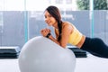 Beautiful young smiling Asian woman training pilates, yoga plank at gym with exercise ball Royalty Free Stock Photo