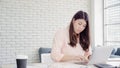 Beautiful young smiling asian woman working laptop on desk in living room at home. Asia business woman writing notebook document Royalty Free Stock Photo