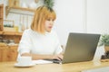 Beautiful young smiling Asian woman working on laptop while at home in office work space. Royalty Free Stock Photo