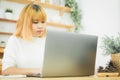 Beautiful young smiling Asian woman working on laptop while at home in office work space. Royalty Free Stock Photo