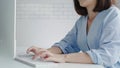 Beautiful young smiling Asian woman working on laptop while at home in office work space. Businesswoman working from home via Royalty Free Stock Photo