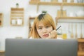 Beautiful young smiling asian woman working on laptop while sitting in a living room at home. Royalty Free Stock Photo