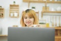 Beautiful young smiling asian woman working on laptop while sitting in a living room at home. Royalty Free Stock Photo