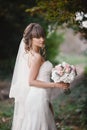 Beautiful young smiling bride holds large wedding bouquet with pink roses. Wedding in rosy and green tones. wedding day