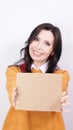 Beautiful young smiling brunette woman in yellow sweater holding blank placard with Copy Space for advertisement. Selective focus Royalty Free Stock Photo