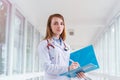 Beautiful young smiling female doctor portrait with folder