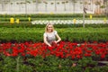 Beautiful young smiling girl, worker with flowers in greenhouse. Concept work in the greenhouse, flowers. Copy space