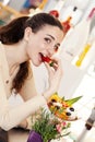 Beautiful young smiling woman with cup of fruit salad with ice cream on top at the cafe coffee bar, ice cream shop and pastry shop Royalty Free Stock Photo