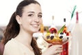 Beautiful young smiling woman with cup of fruit salad with ice cream on top at the cafe coffee bar, ice cream shop and pastry shop Royalty Free Stock Photo