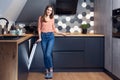 Beautiful young smiling woman doing dishes in the kitchen