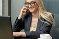 Young woman is talking by cell phone in office Royalty Free Stock Photo