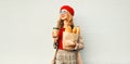 Beautiful young smiling woman holding coffee cup, grocery shopping paper bag with long white bread baguette looking away on blank Royalty Free Stock Photo