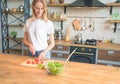 Beautiful young smiling woman making salad in the kitchen. Cutting tomatoes. Healthy food. vegetable salad. Diet. Healthy Royalty Free Stock Photo
