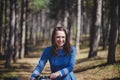 Beautiful young smiling woman with short dark hair and hat standing near bicycle with basket of huge bouquet of Royalty Free Stock Photo