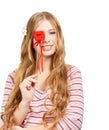 Beautiful young smiling woman in thoughtful pose with red valentine heart