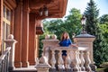 Beautiful young smiling woman walking in city park near famous old architecture building at summer day wearing dress and looking Royalty Free Stock Photo